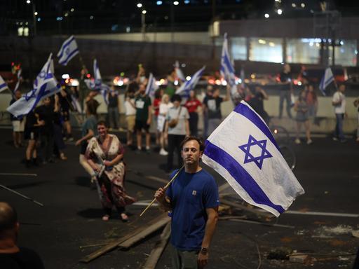 Israelische Demonstranten halten Fahnen und blockieren die Ayalon-Autobahn während eines Protestes gegen die Pläne der Regierung von Premierminister Benjamin Netanjahu, das Justizsystem zu reformieren.