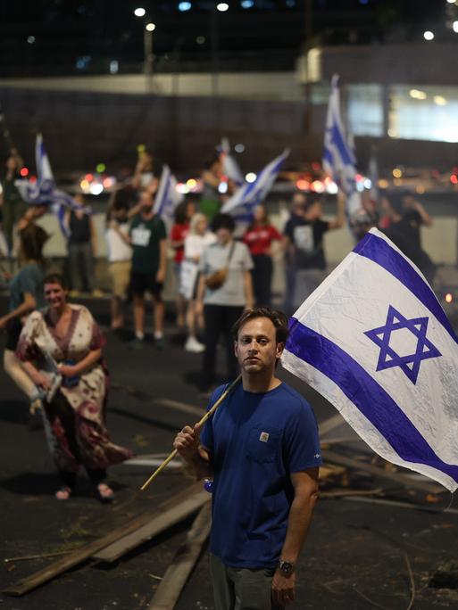 Israelische Demonstranten halten Fahnen und blockieren die Ayalon-Autobahn während eines Protestes gegen die Pläne der Regierung von Premierminister Benjamin Netanjahu, das Justizsystem zu reformieren.