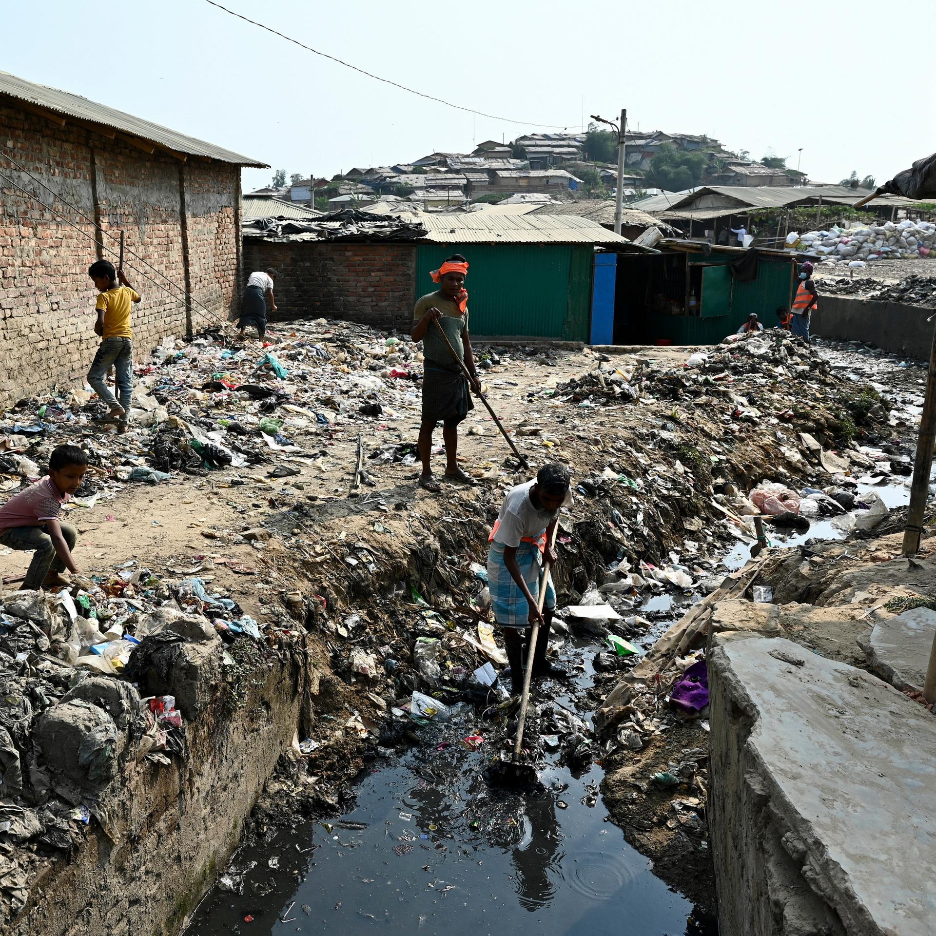 Angehörige des Volkes der Rohingya reinigen einen Dränagegraben im Flüchtlingslager Balukhali in Bangladesh, Bezirk Cox's Bazar