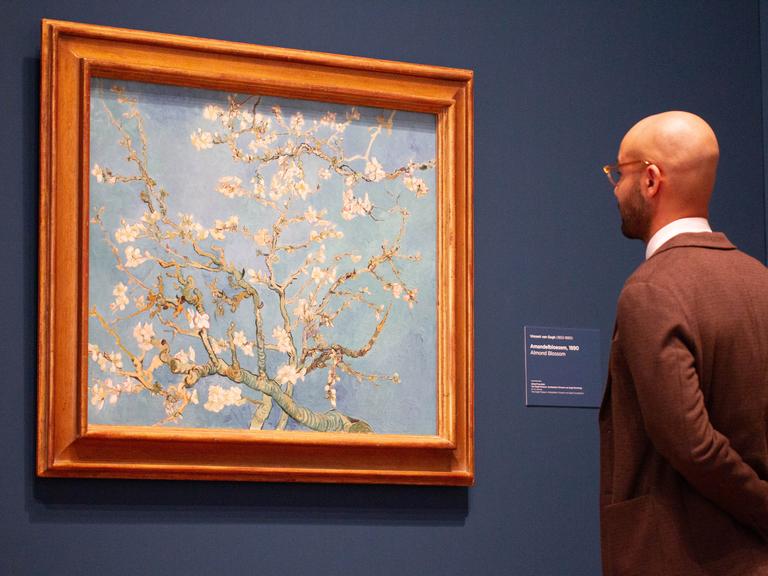 Ein Besucher steht vor dem berühmten Mandelblüten Bild von Vincent van Gogh in der Jubiläums-Sonderausstellung "Choosing Vincent - Portrait of a Family History" im Van Gogh Museum in Amsterdam, 2023.