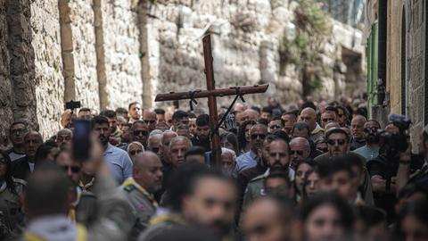 Christen ziehen im April 2023 mit einem hölzernen Kreuz durch die Pilgerstraße in Jerusalem.