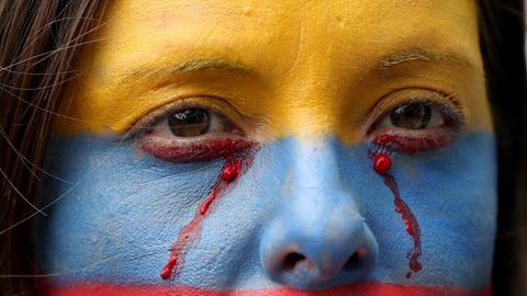 Eine regierungskritische Demonstrantin, deren Gesicht mit den Farben der kolumbianischen Nationalflagge bemalt ist, bei einem Protest in Bogota, Kolumbien