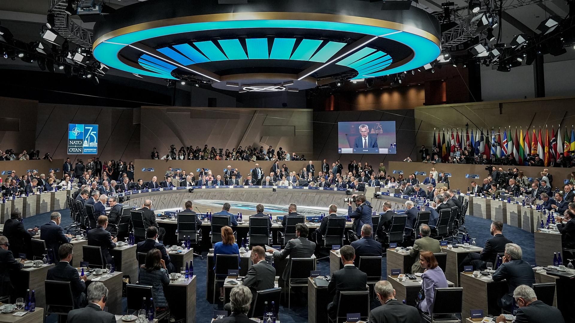 Die Staats- und Regierungschefs von der NATO sitzen in einem Saal in der Stadt Washington in dem Land USA.