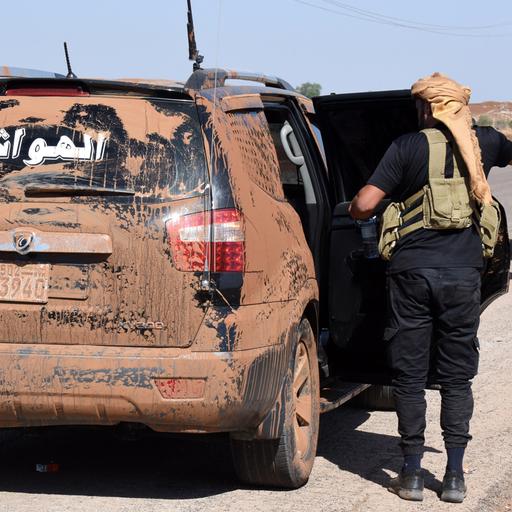 Kämpfer der Beduinen steigen in ein völlig verschmutztes Auto.