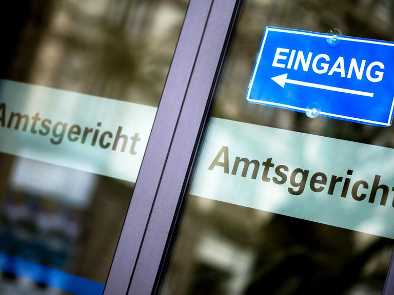 20.11.2017, Niedersachsen, Hannover: Ein blaues Schild weist an einer Glastür auf den Eingang am Amtsgericht hin. Foto: Hauke-Christian Dittrich