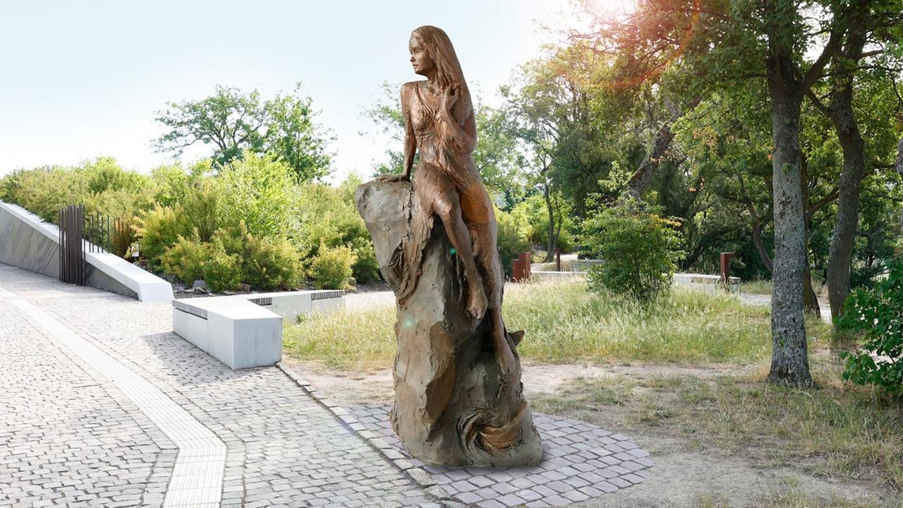 Die neue Loreley-Statue zeigt eine bronzene Frau, die auf einem Felsen sitzt und sich das lange Haar kämmt.