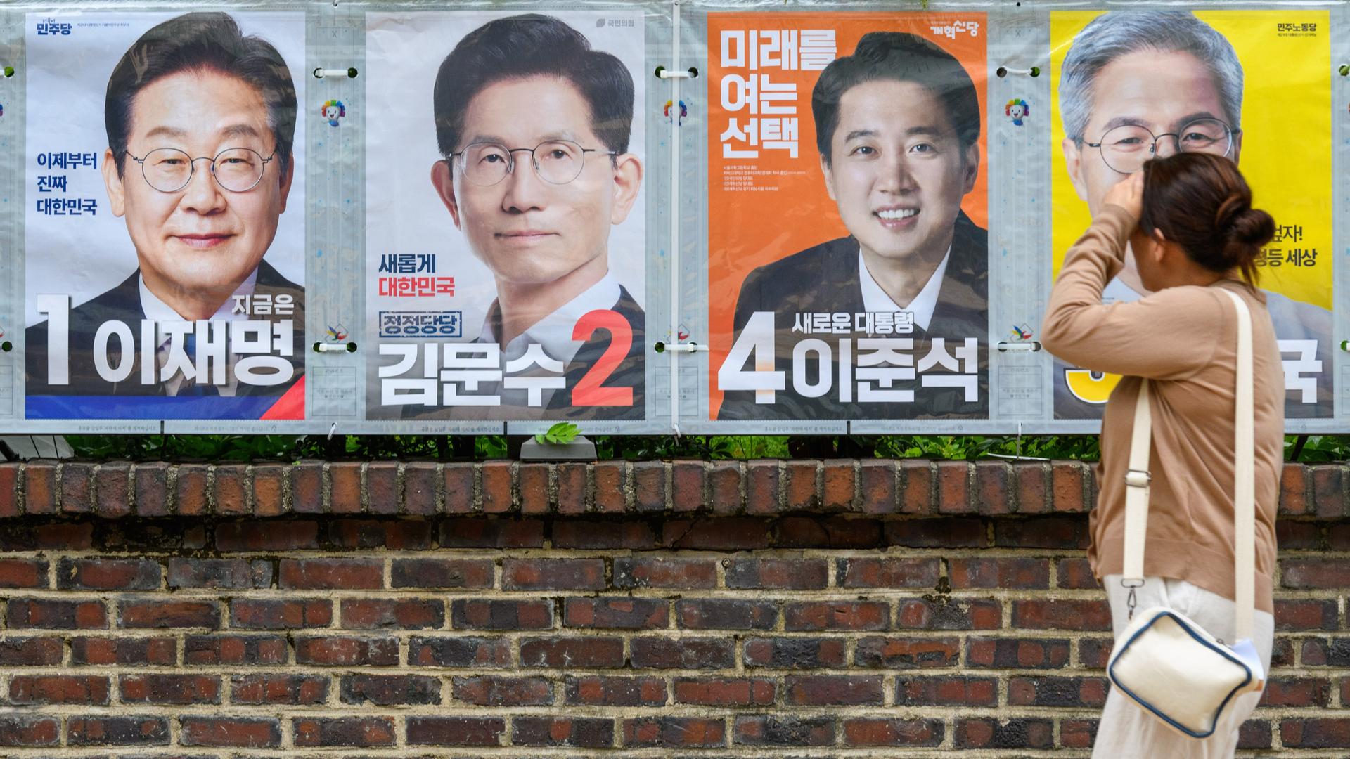 Menschen gehen in Seoul an den Wahlplakaten der Präsidentschaftskandidaten vorbei. Menschen gehen in Seoul an den Wahlplakaten der Präsidentschaftskandidaten vorbei.