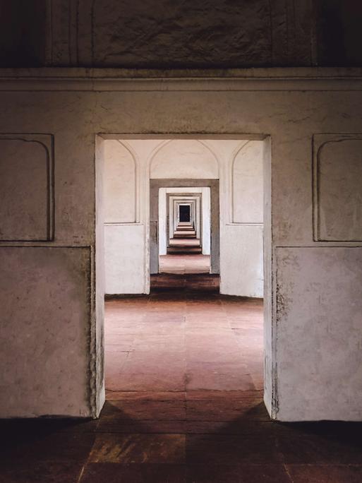 Ein leeres Gebäude in Lahore, Pakistan: Blick durch eine Tür, die zu einem leeren Raum mit Tür führt, die zu einem leeren Raum mit Tür führt, die zu einem leeren Raum mit Tür führt usw...