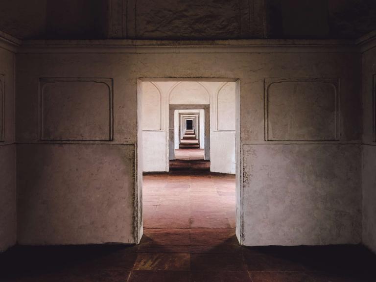 Ein leeres Gebäude in Lahore, Pakistan: Blick durch eine Tür, die zu einem leeren Raum mit Tür führt, die zu einem leeren Raum mit Tür führt, die zu einem leeren Raum mit Tür führt usw...