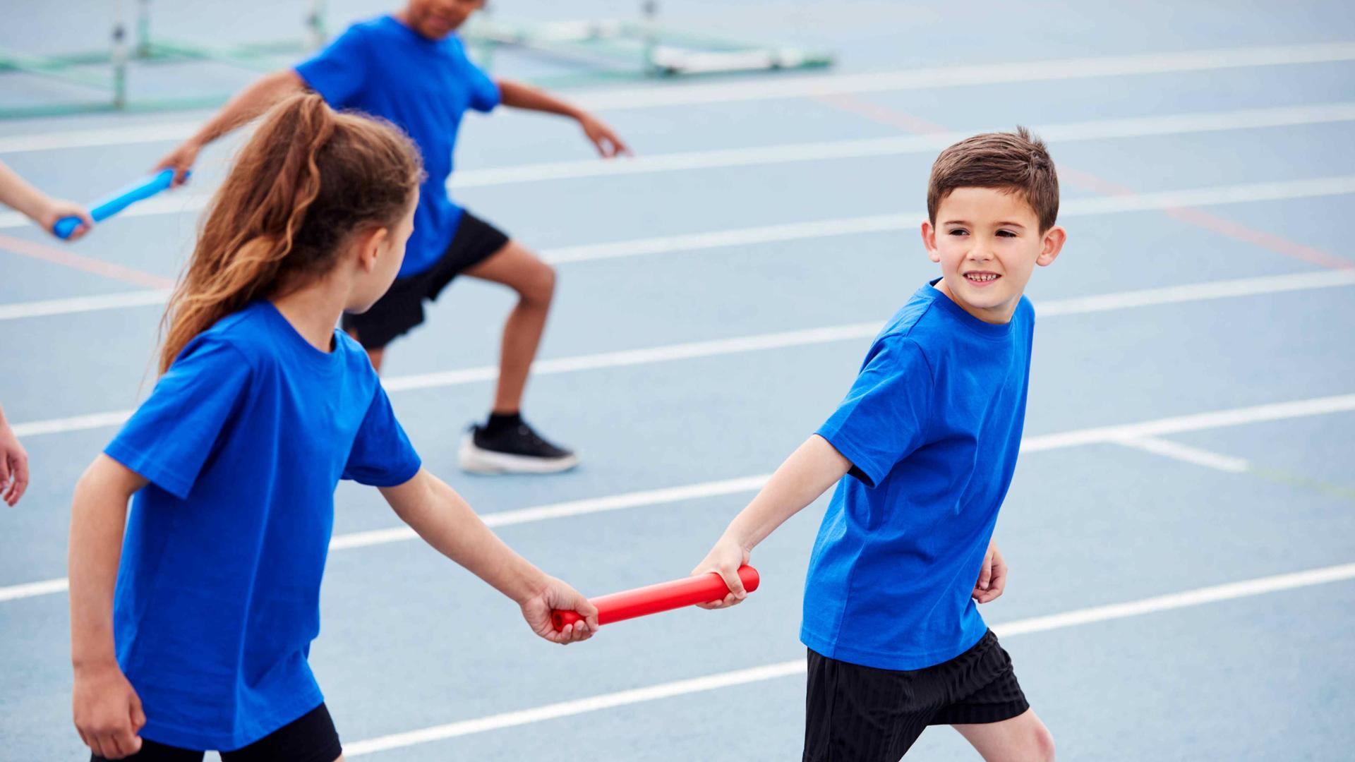 Kinder mit Staffelstab beim Team-Lauftraining