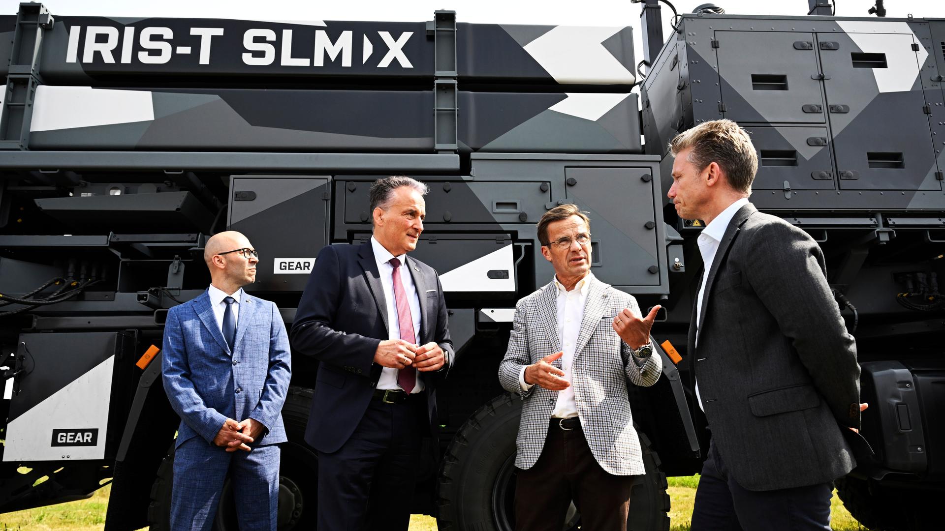 Der Vorstandsvorsitzende von Diehl Defence Helmut Rauch (2.v.l), Schwedens Ministerpräsident Ulf Kristersson (2.v.r) und der schwedische Verteidigungsminister Pal Jonson (r) sprechen vor einem IRIS-T SLM, einem deutschen Flugabwehrraketen-System, im schwedischen Armeeregiment P18 in Visby.