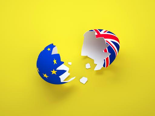 Illustration: Eine zerbrochene Eierschale mit den Flaggen Europas und Großbritanniens auf gelbem Hintergrund