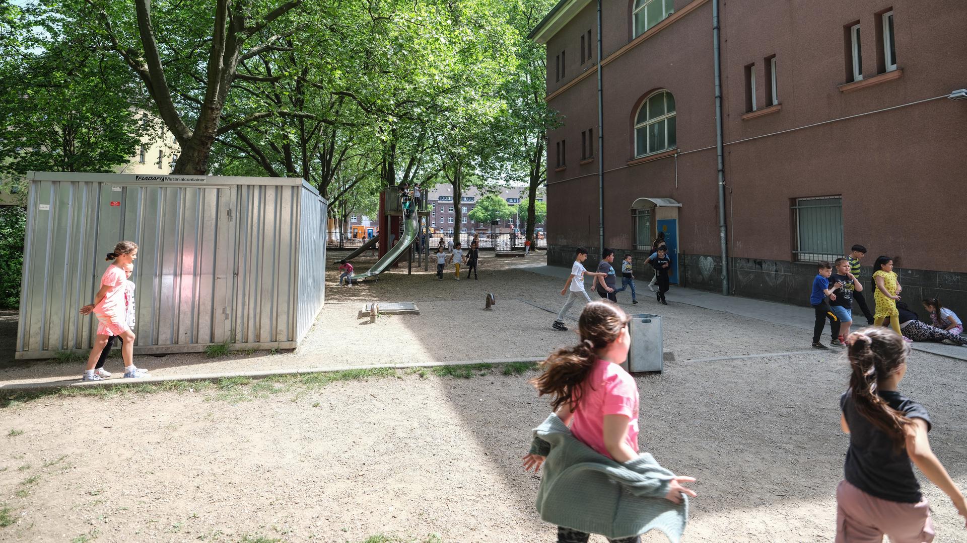 Auf dem Schulhof der Grundschule GGS am Hochfelder Markt in Duisburg spielen Kinder an einem Klettergerüst.