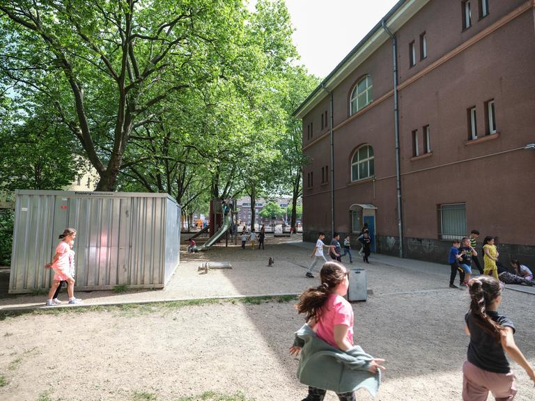 Auf dem Schulhof der Grundschule GGS am Hochfelder Markt in Duisburg spielen Kinder an einem Klettergerüst.