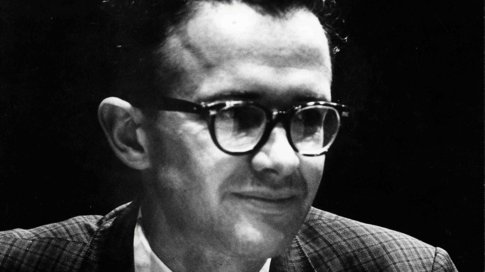 Ein Mann mit Brille und Krawatte blickt seitlich an der Kamera vorbei Ein Mann mit Brille und Krawatte blickt seitlich an der Kamera vorbei