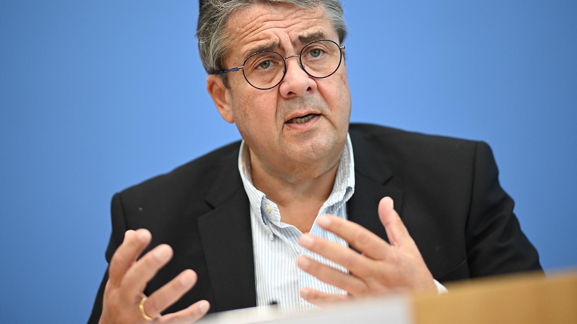 Sigmar Gabriel (SPD), Vorsitzender der Atlantik-Brücke e.V., spricht über die Situation in den USA vor der Präsidentschaftswahl. Er steht dabei vor einem blauen Hintergrund und gestikuliert beim sprechen.