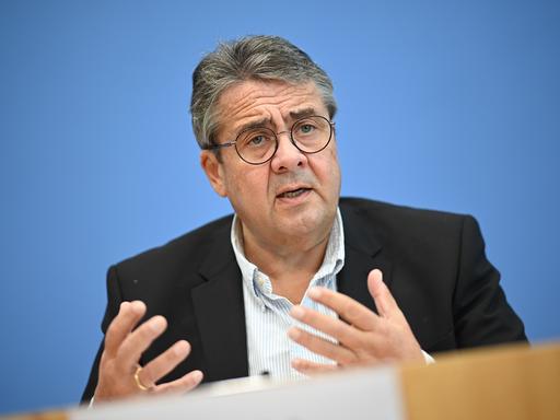 Sigmar Gabriel (SPD), Vorsitzender der Atlantik-Brücke e.V., spricht über die Situation in den USA vor der Präsidentschaftswahl. Er steht dabei vor einem blauen Hintergrund und gestikuliert beim sprechen.