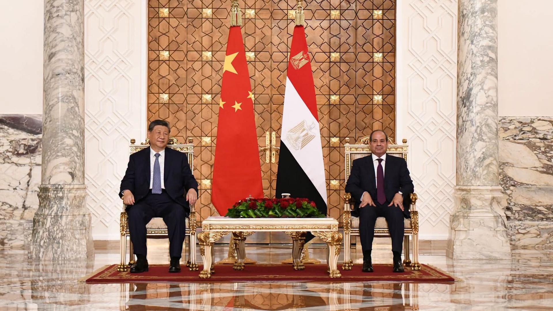 Der chinesische Präsident Xi Jinping sitzt vor den Landesflaggen neben dem ägyptischen Präsidenten Abdel Fatah al-Sisi. Der chinesische Präsident Xi Jinping sitzt vor den Landesflaggen neben dem ägyptischen Präsidenten Abdel Fatah al-Sisi.