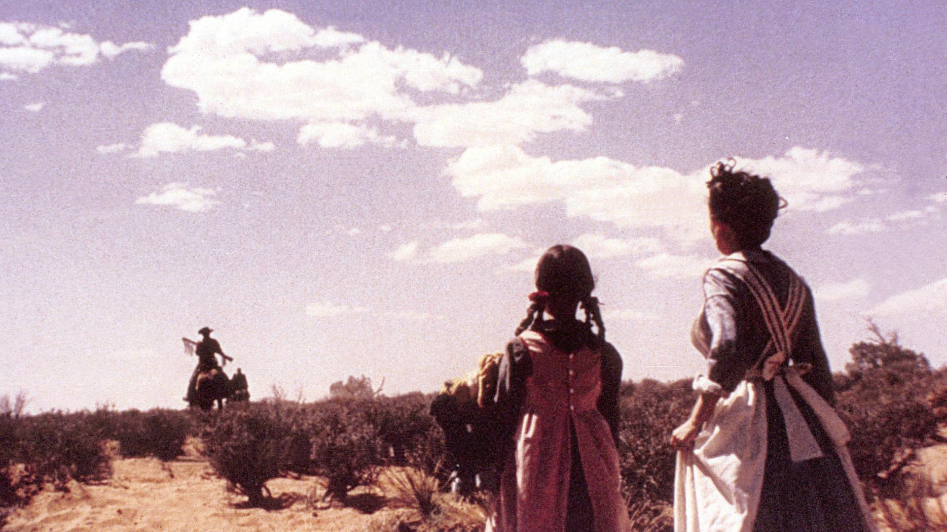 Immer wieder übel: Abschied, so wie hier in unserem Top-Five-Film "The Searchers" mit John Wayne. Im Vordergrund stehen zwei Frauen und winken, im Hintergrund reitet ein Cowboy aus dem Bild. 