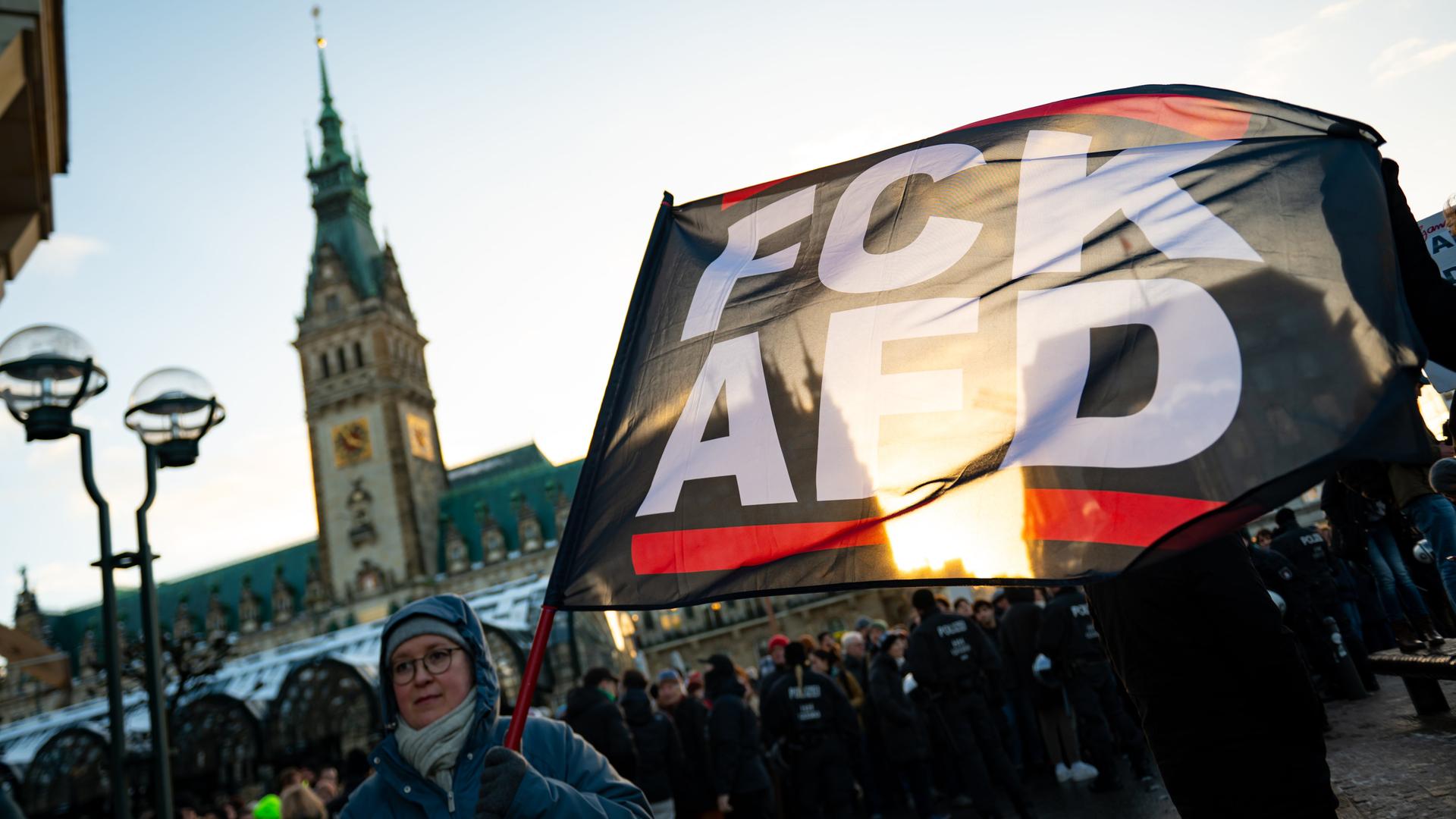 "FCK AFD" steht auf einer Fahne vor dem Hamburger Rathaus bei einer Demonstration gegen Rechts. 