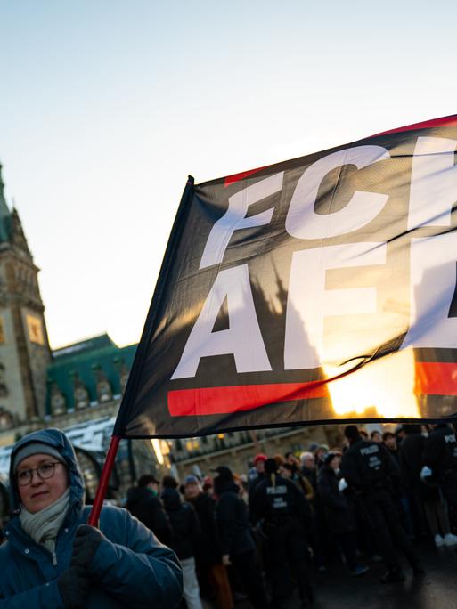 "FCK AFD" steht auf einer Fahne vor dem Hamburger Rathaus bei einer Demonstration gegen Rechts. 