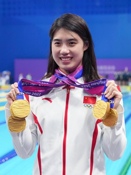 Die chinesische Star-Schwimmerin Zhang Yufei hält stolz ihre Goldmedaillen bei den 19. Asienspielen im September 2023 in die Kamera.