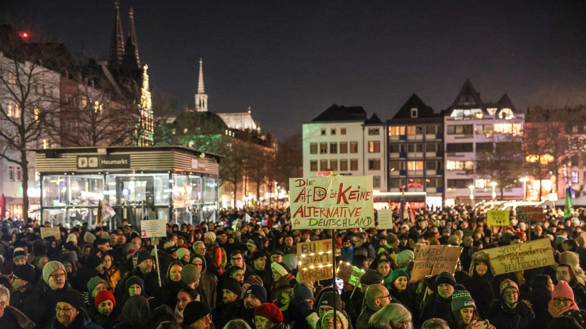 Demonstranten stehen auf dem Platz "Heumarkt" in Köln. Im Hintergrund ist der Kölner Dom. Zu sehen ist auch ein Plakat, auf dem steht: "Die AfD ist keine Alternative für Deutschland."