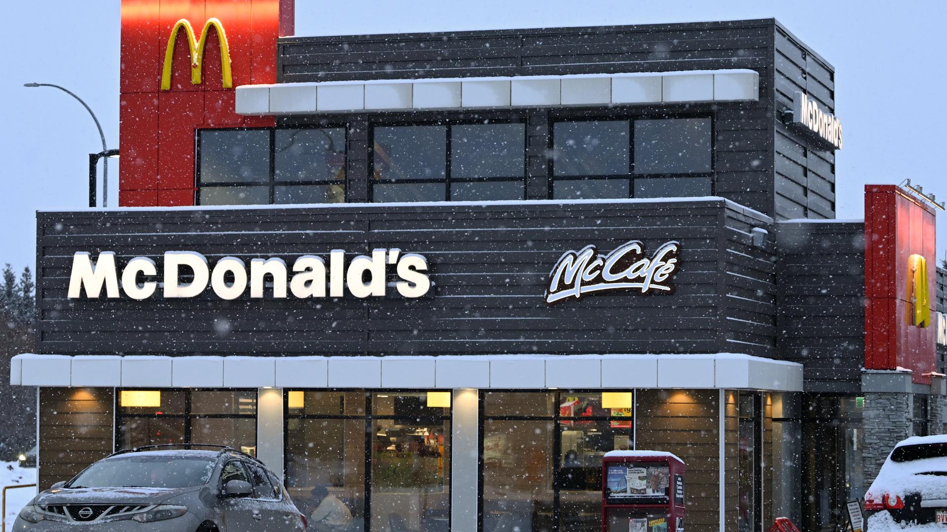 McDonald's Restaurant in South Edmonton in den USA. Vor dem Lokal parkt ein Auto in einer verschneiten Straße. 