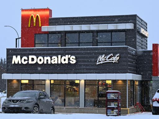 McDonald's Restaurant in South Edmonton in den USA. Vor dem Lokal parkt ein Auto in einer verschneiten Straße. 