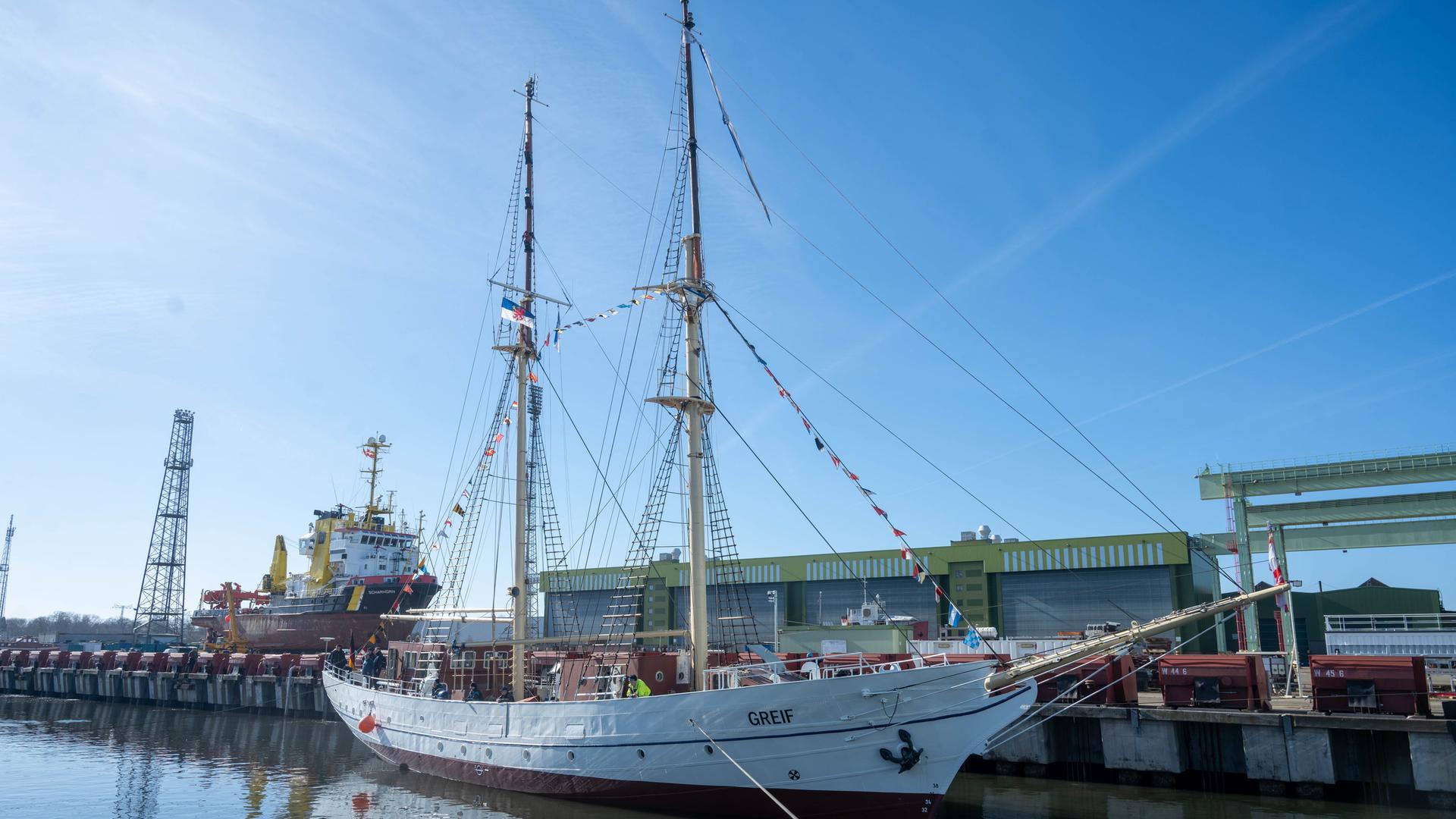 Das Segelschulschiff "Greif" liegt in einem Hafen.