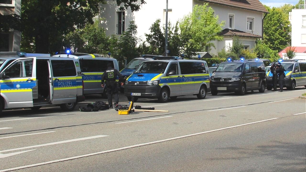 Polizisten sind im Einsatz bei einer mutmaßlichen Geiselnahme in einer Bankfiliale in Regensburg. Das Bild zeigt mehrere Mannschaftswagen und Polizisten davor. Polizisten sind im Einsatz bei einer mutmaßlichen Geiselnahme in einer Bankfiliale in Regensburg. Das Bild zeigt mehrere Mannschaftswagen und Polizisten davor.