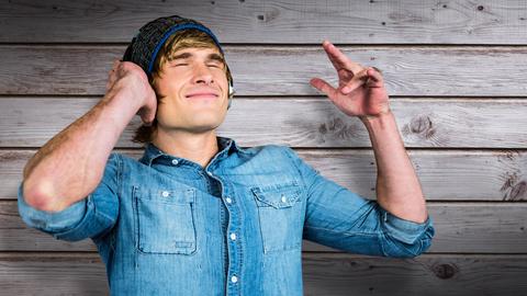 Ein junger Mann hört per Kopfhörer Musik oder Podcasts.