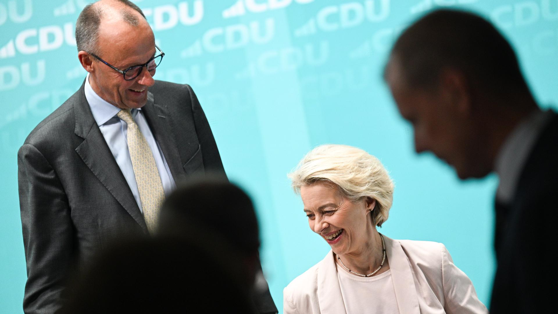 Friedrich Merz und Ursula von der Leyen auf einer Pressekonferenz nach einer Bundesvorstandssitzung der CDU im Konrad-Adenauer-Haus. Merz steht und blick auf von der Leyen hinab, die sitzt. Beide lachen. 