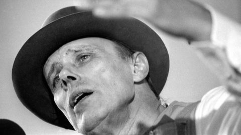 Der Künstler Joseph Beuys in Untersicht auf einem Schwarz-Weiß-Foto. Er diskutiert. Der Künstler Joseph Beuys in Untersicht auf einem Schwarz-Weiß-Foto. Er diskutiert.