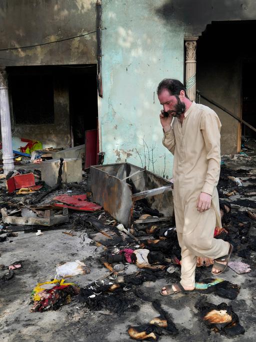 Ein Mann betrachtet die Trümmer eines Wohnhauses.