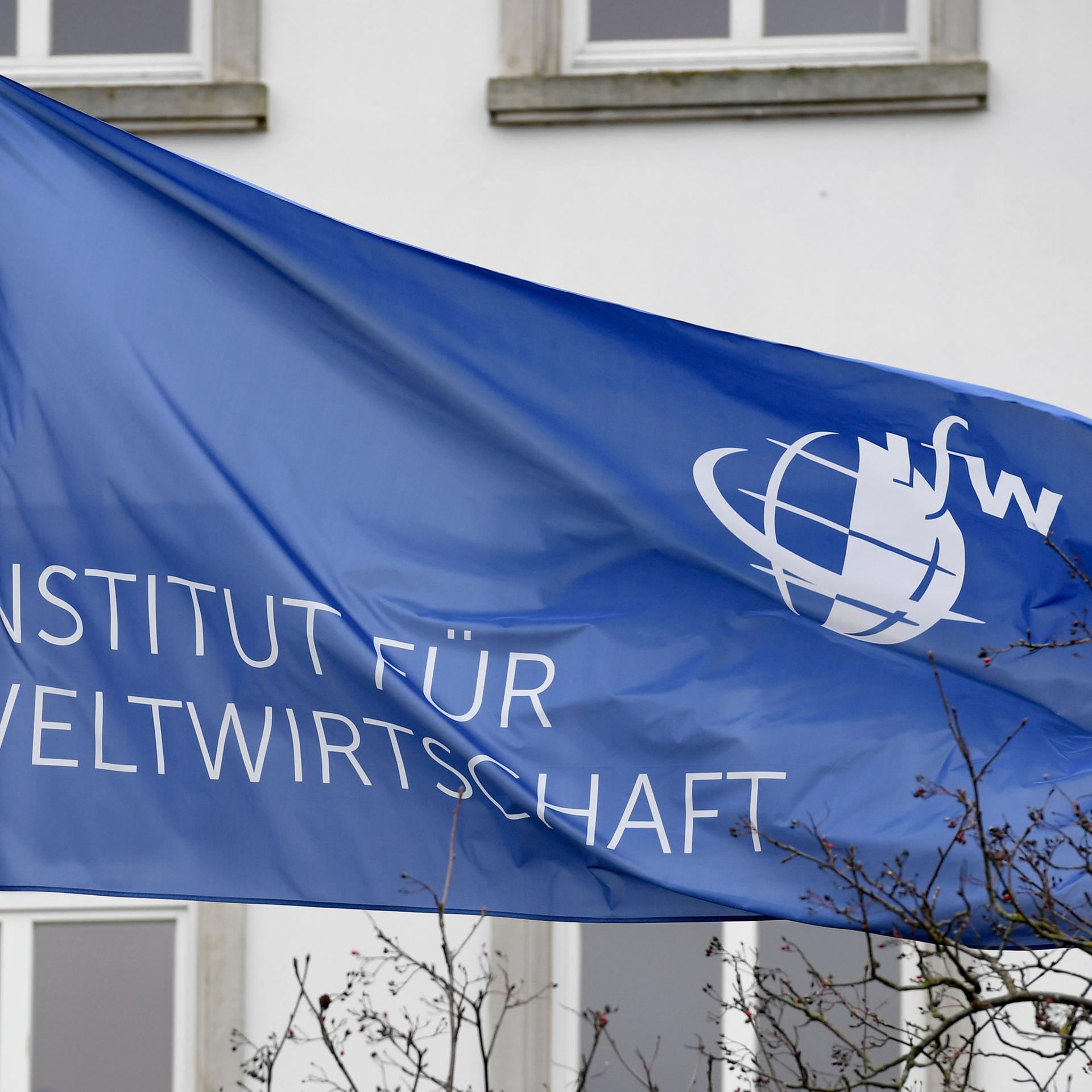 Das Logo des Instituts für Weltwirtschaft (IfW) ist auf einer Fahne an dem Gebäude an der Förde in Kiel zu sehen. 