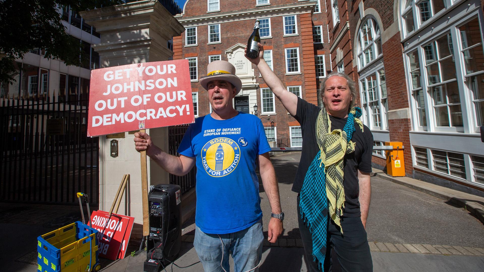 Zwei Anti-Boris-Johnson-Demonstranten feiern die Niederlagen der Torys in den Wahlkreisen Devon und Wakefield bei Nachwahlen 