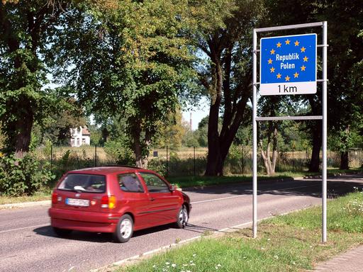 Ein Bild von 2005 zeigt ein rotes Auto, dass an einem Schild mit der Aufschrift "Republik Polen, ein Kilometer" zeigt.