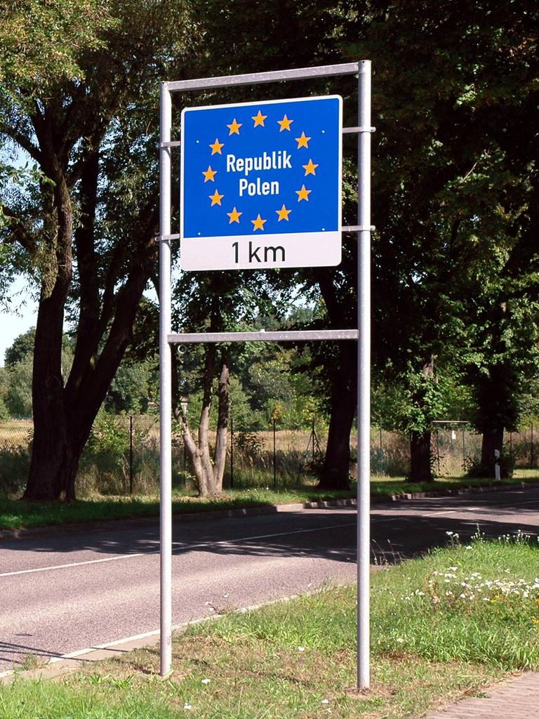 Ein Bild von 2005 zeigt ein rotes Auto, dass an einem Schild mit der Aufschrift "Republik Polen, ein Kilometer" zeigt.