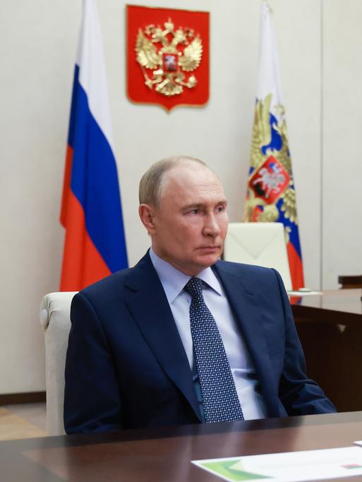 Russlands Präsident Wladimir Putin in seinem Büro mit der russischen Fahne im Hintergrund
