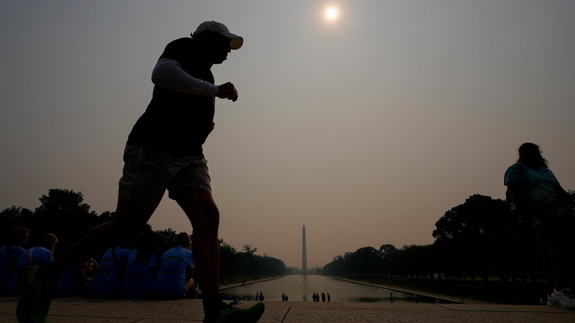 Ein Jogger läuft im Vordergrund, im Hintergrund sieht man das Washington Monument, das völlig im Dunst liegt. Ein Jogger läuft im Vordergrund, im Hintergrund sieht man das Washington Monument, das völlig im Dunst liegt.