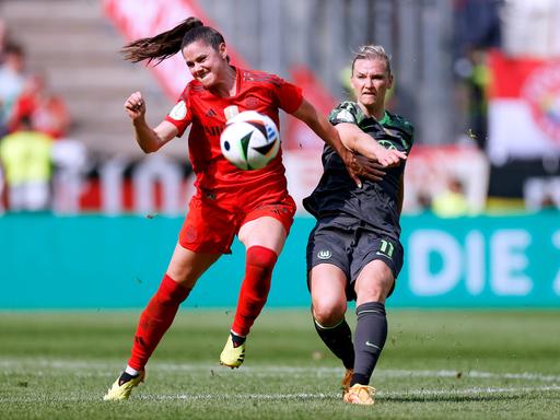 Im DFB-Pokalfinale der Frauen kämpfen Bayern Münchens Sarah Zadrazil und Wolfsburgs Kapitänin Alexandra Popp um den Ball.