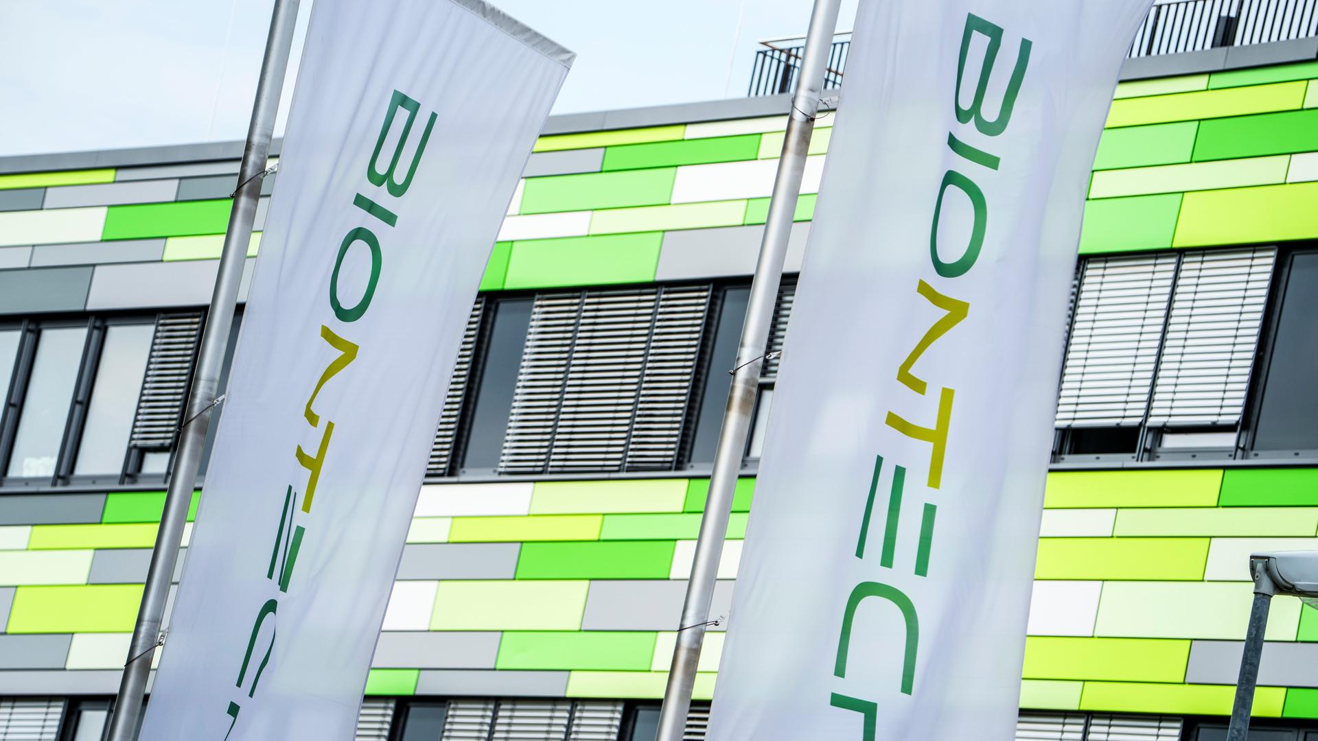 Die Flaggen des Pharma-Unternehmens Biontech flattern vor der Firmenzentrale in Mainz im Wind. 