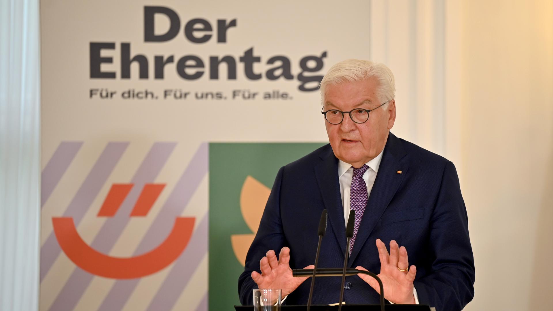 Bundespräsident Steinmeier steht an einem Redepult. Hinter ihm steht ein Plakat mit der Aufschrift "Der Ehrentag. Für dich. Für uns. Für alle." Bundespräsident Steinmeier steht an einem Redepult. Hinter ihm steht ein Plakat mit der Aufschrift "Der Ehrentag. Für dich. Für uns. Für alle."