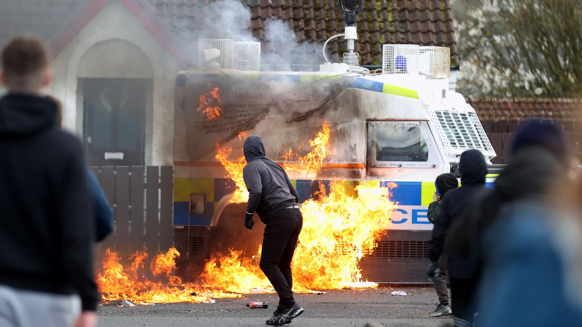 Nordirland, Londonderry: Jugendliche werfen Benzinbomben auf einen Land Rover der Polizei, während republikanische Demonstranten, die gegen das Karfreitagsabkommen sind, eine Parade abhalten.