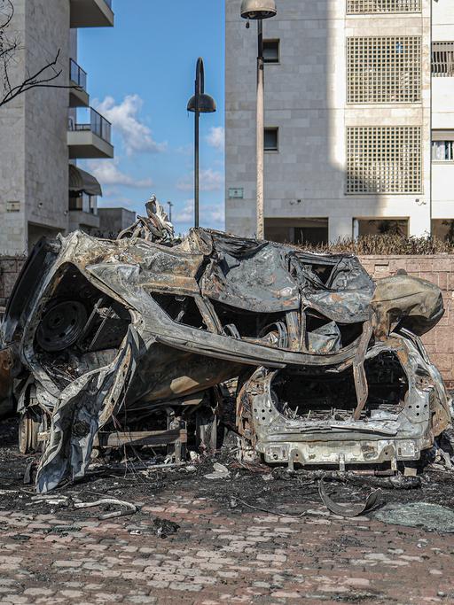 Ein Blick auf die Schäden eines Raketenangriffs aus Gaza, zerstörte und ausgebrannte Autos in einem Wohngebiet in Israel.