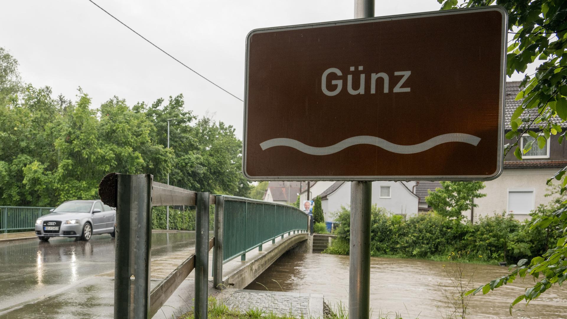 Ein Auto fährt über die Günz, deren Pegel beinahe bis zur Fahrbahn reicht