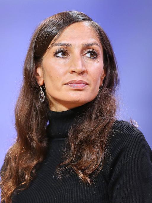 Porträtaufnahme von Gilda Sahebi vor violettem Hintergrund