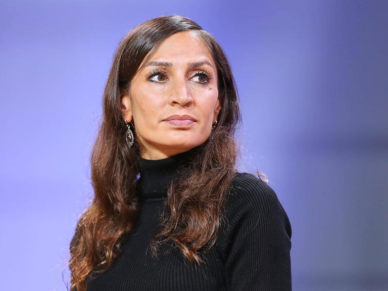 Porträtaufnahme von Gilda Sahebi vor violettem Hintergrund