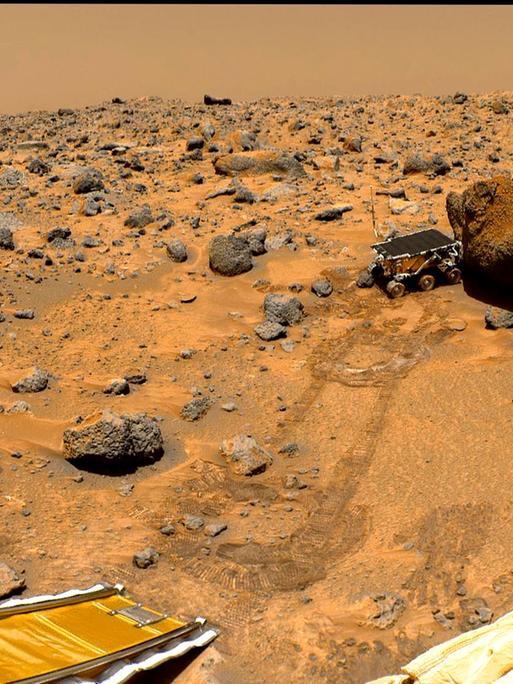 Der kleine Rover Sojourner im Sommer 1997 beim Betrachten eines Steins auf dem Mars 